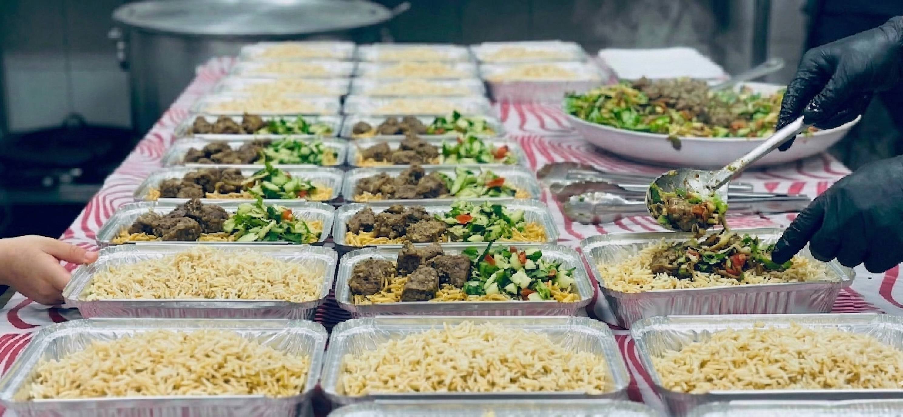Trays of rice, meat and salad lined up and ready